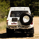 White off-road vehicle with spare tire on a dirt road
