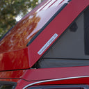 Red vehicle with a 'Headspace Campers HI' label on a blurred natural background