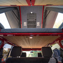 Open roof of a vehicle with wooden paneling and built-in speakers.