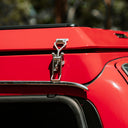 Close-up of a red vehicle's roof rack with a metallic clip.