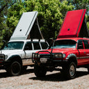 Two off-road vehicles with open roofs parked outdoors.