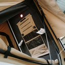 Foldable chair inside a vehicle with a beige cover
