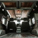 Interior of a van with wooden ceiling and electronic equipment.